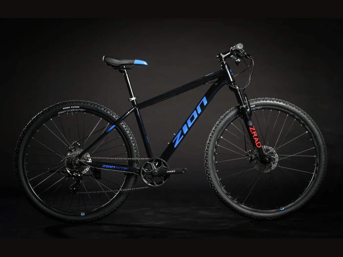 Bicicleta Zion Frisk negra con detalles azules, de perfil sobre fondo oscuro